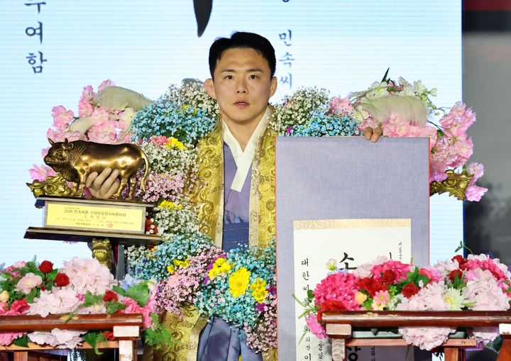 [서울=뉴시스] 24일 충청북도 단양군 단양체육관 동관에서 열린 '위더스제약 2026 민속씨름 단양온달장사씨름대회' 소백장사(72㎏ 이하)에 등극한 김성하(창원특례시청)가 장사꽃가마를 타고 장사인증서와 황소트로피를 들고 기념사진을 찍고 있다. (사진=대한씨름협회 제공) 2026.03.24. photo@newsis.com *재판매 및 DB 금지