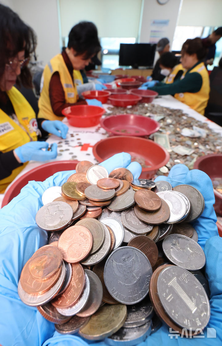 [인천=뉴시스] 전진환 기자 = 대한적십자사 인천지사 직원 및 봉사원들이 24일 오전 인천시 연수구 대한적십자사 인천지사에서 인천국제공항에 설치한 적십자 모금함에 내ㆍ외국인 탑승자들이 기부한 세계 각국의 동전과 지폐를 분류하고 있다.  모금된 동전과 지폐는 국제협력기금으로 적립되며, 일부는 국내구호기금으로 사용된다.  2026.03.24. amin2@newsis.com