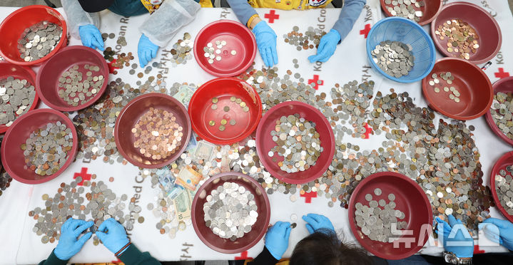 [인천=뉴시스] 전진환 기자 = 대한적십자사 인천지사 직원 및 봉사원들이 24일 오전 인천시 연수구 대한적십자사 인천지사에서 인천국제공항에 설치한 적십자 모금함에 내ㆍ외국인 탑승자들이 기부한 세계 각국의 동전과 지폐를 분류하고 있다.  모금된 동전과 지폐는 국제협력기금으로 적립되며, 일부는 국내구호기금으로 사용된다.  2026.03.24. amin2@newsis.com