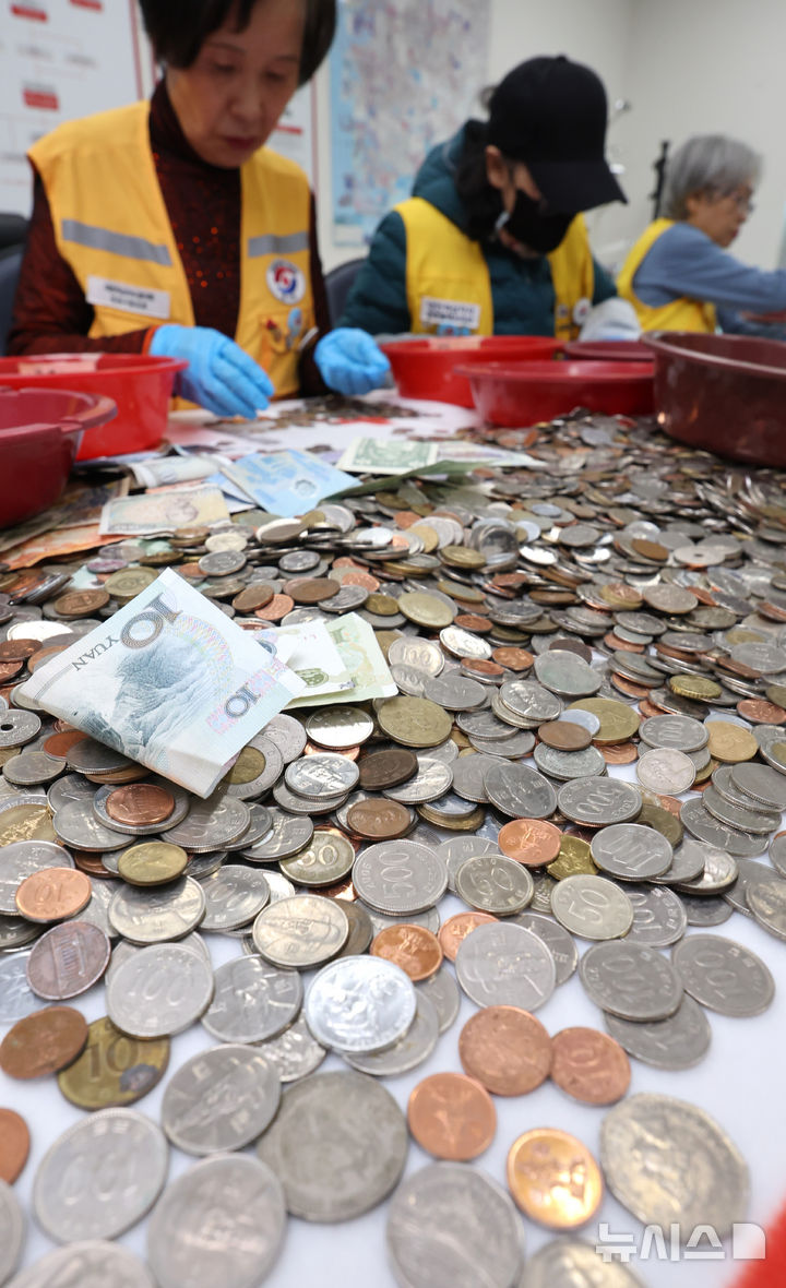 [인천=뉴시스] 전진환 기자 = 대한적십자사 인천지사 직원 및 봉사원들이 24일 오전 인천시 연수구 대한적십자사 인천지사에서 인천국제공항에 설치한 적십자 모금함에 내ㆍ외국인 탑승자들이 기부한 세계 각국의 동전과 지폐를 분류하고 있다.  모금된 동전과 지폐는 국제협력기금으로 적립되며, 일부는 국내구호기금으로 사용된다.  2026.03.24. amin2@newsis.com