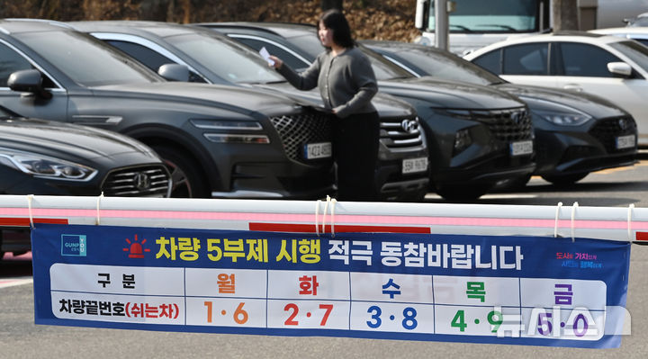 [군포=뉴시스] 김종택 기자 = 24일 경기 군포시청 주차장에서 직원이 차량 5부제 시행 안내문을 부착하고 있다. 정부는 중동 사태로 원유 수급 위기가 확산되자 내일부터 공공부문에 대한 승용차 5부제를 시행한다. 2026.03.24. jtk@newsis.com