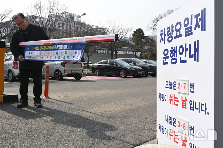 [군포=뉴시스] 김종택 기자 = 24일 경기 군포시청 주차장 입구에서 직원들이 내일부터 시행하는 차량 5부제를 앞두고 안내문을 설치하고 있다.&nbsp; 정부는 중동 사태로 원유 수급 위기가 확산되자 내일부터 공공부문에 대한 승용차 5부제를 시행한다. 2026.03.24. jtk@newsis.com