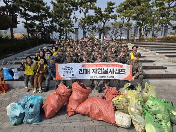 [창원=뉴시스] 경남 창원시 진해자원봉사캠프 캠프 관계자들과 해군 전투체계학부 장병들이 24일 진해루 일원에서 군항제를 앞두고 해안 환경정화 활동에 참가한 후 기념촬영을 하고 있다. (사진=창원시 제공) 2026.03.25. photo@newsis.com *재판매 및 DB 금지