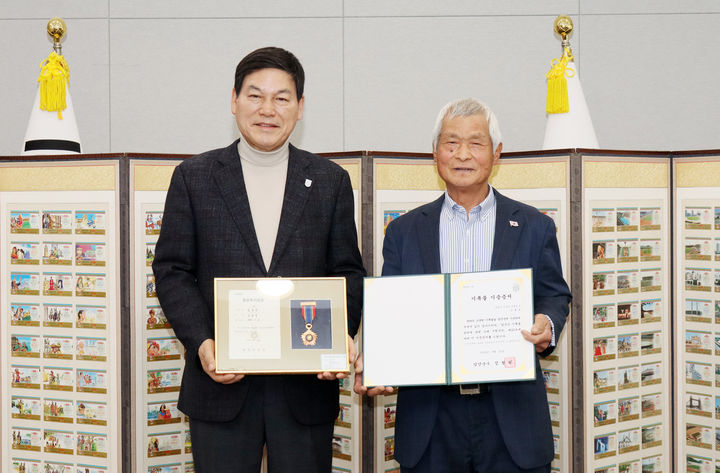[담양=뉴시스] 송창헌 기자 = 등불장학금 기탁자이기도 한 임홍균(오른쪽)씨가 25일 담양군에 1988년 서울올림픽 복권과 88올림픽 기장을 기증한 뒤 정철원 군수와 기념사진을 찍고 있다. (사진=담양군 제공) 2026.03.25 photo@newsis.com *재판매 및 DB 금지