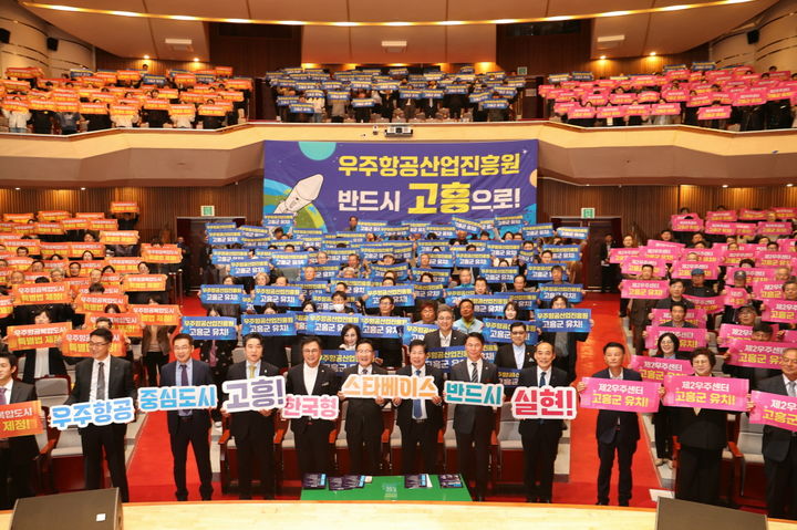 [고흥=뉴시스] 25일 고흥문화회관에서 열린 우주항공복합도시 조성 결의대회 및 포럼에서 참석자들이 우주항공산업진흥원 고흥 유치 의지를 담은 손피켓을 들고 퍼포먼스를 펼치고 있다. (사진=고흥군 제공) 2026.03.25. photo@newsis.com *재판매 및 DB 금지