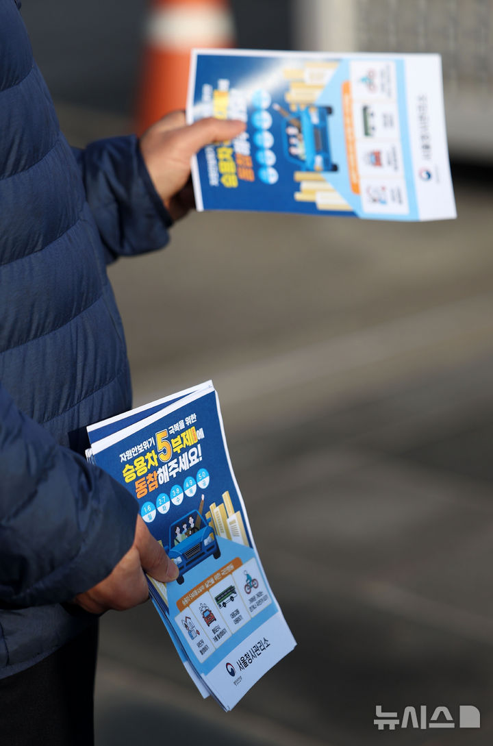 [서울=뉴시스] 김선웅 기자 = 원유 수급 위기와 관련해 공공부문 승용차 5부제 의무시행이 시작된 25일 서울 종로구 정부서울청사에서 관계자가 5부제 동참 캠페인을 펼치고 있다. 2026.03.25. mangusta@newsis.com