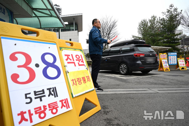 [광주=뉴시스] 이현행 기자 = 중동전쟁 여파에 따른 에너지 절약 정책으로 차량 5부제가 시행된 첫날인 25일 오전 광주 서구청에서 한 차량이 청원경찰의 안내를 받고 진입하고 있다. 2026.03.25. lhh@newsis.com