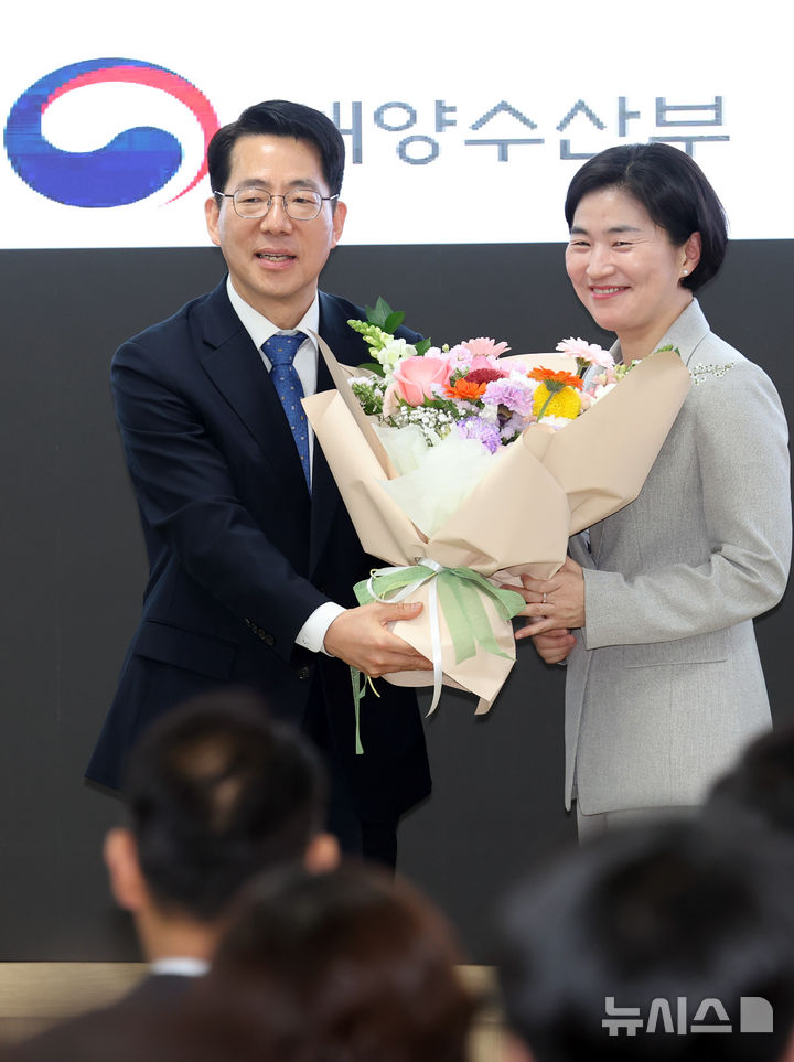 [부산=뉴시스] 하경민 기자 = 황종우 해양수산부 장관이 25일 부산 동구 해양수산부 별관 대회의실에서 열린 취임식에 참석, 직원 대표로부터 축하 꽃다발을 받고 있다. 2026.03.25. yulnetphoto@newsis.com