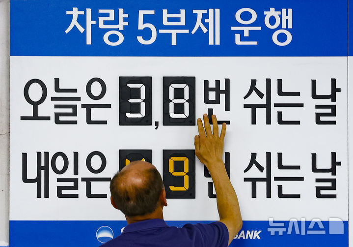 [서울=뉴시스] 김근수 기자 = 지난 25일 오전 서울 중구 우리은행 본점 주차장에서 한 주차 안내원이 차량 5부제 숫자를 조정하고 있다. 2026.03.25. ks@newsis.com