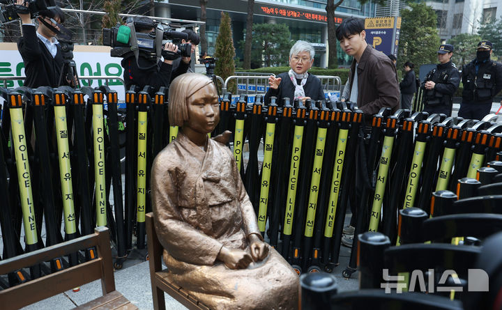 [서울=뉴시스] 김선웅 기자 = 서울 종로구 옛 주한 일본대사관 인근 평화의 소녀상을 둘러싼 경찰 바리케이드가 수요시위 시간대에만 제한적으로 개방된다. 사진은 평화의 소녀상 제작자 김서경 작가가 지난 25일 서울 종로구 옛 주한 일본대사관 인근 평화의 소녀상 앞에서 열린 제1745차 일본군 성노예제 문제해결을 위한 수요시위에서 소녀상 상태를 점검, 설명하는 모습. 2026.03.31. mangusta@newsis.com