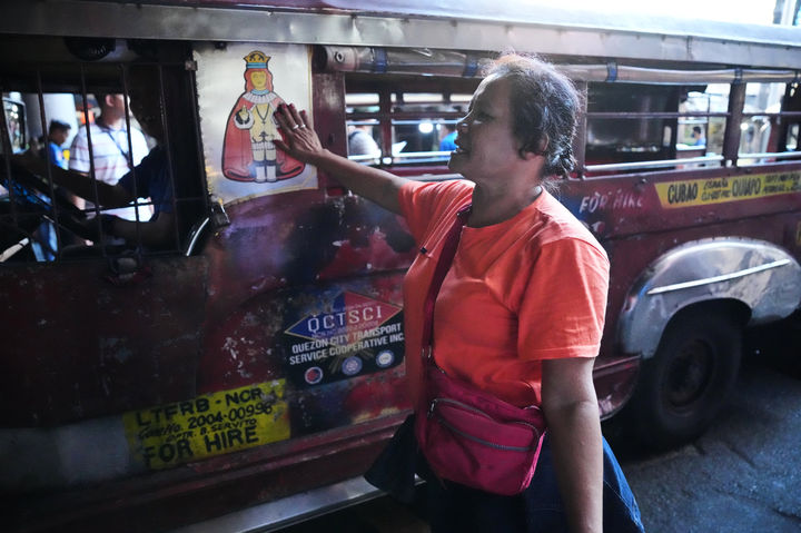 [케손시티=AP/뉴시스] 26일(현지 시간) 필리핀 케손시티에서 유가 상승이 계속되는 가운데 한 여성이 지프니 운전자에게 운송 파업에 동참할 것을 권유하고 있다. 2026.03.26.
