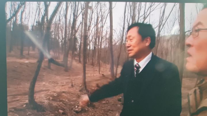 [수원=뉴시스] 이국성씨와 유해가 매장돼 있을 것으로 추정되는 곳을 둘러보는 모습. (사진=안태근 회장 제공) 2026.03.26. photo@newsis.com *재판매 및 DB 금지