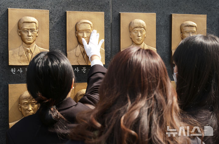 [서울=뉴시스] 김종택 기자 = 26일 경기 평택시 해군 제2함대사령부에서 열린 '제16주기 천안함 46용사 추모식'에서 천안함 유가족들이 추모비를 어루만지고 있다.(공동취재) 2026.03.26. photo@newsis.com