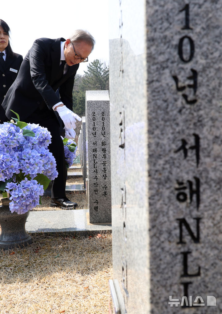 [대전=뉴시스] 강종민 기자 = 천안함 피격 사건 16주기인 26일 이명박 전 대통령이 대전시 유성구 국립대전현충원 천안함 46용사 묘역을 찾아 참배한 뒤 묘비를 살펴보고 있다. 2026.03.26. ppkjm@newsis.com