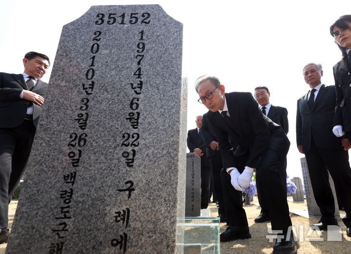 [대전=뉴시스] 강종민 기자 = 천안함 피격 사건 16주기인 26일 이명박 전 대통령이 대전시 유성구 국립대전현충원 천안함 46용사 묘역을 찾아 참배한 뒤 묘비를 살펴보고 있다. 2026.03.26. ppkjm@newsis.com