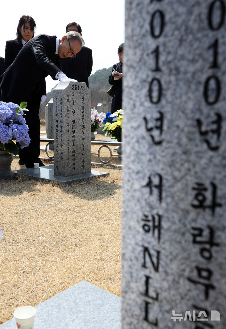 [대전=뉴시스] 강종민 기자 = 천안함 피격 사건 16주기인 26일 이명박 전 대통령이 대전시 유성구 국립대전현충원 천안함 46용사 묘역을 찾아 참배한 뒤 묘비를 살펴보고 있다. 2026.03.26. ppkjm@newsis.com