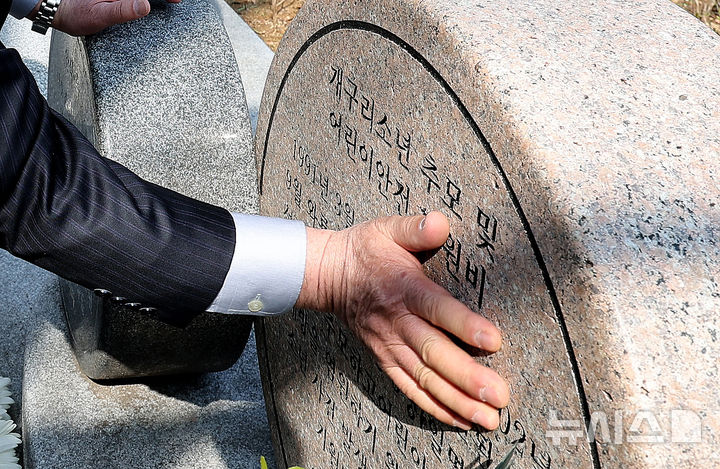 [대구=뉴시스] 이무열 기자 = 26일 대구 달서구 와룡산 선원공원 개구리소년 추모 및 어린이 안전 기원비 앞에서 열린 '개구리소년 35주기 추모제'에 참석한 개구리소년 유족 우철원군의 아버지 우종우씨가 추모비를 어루만지고 있다. 2026.03.26. lmy@newsis.com
