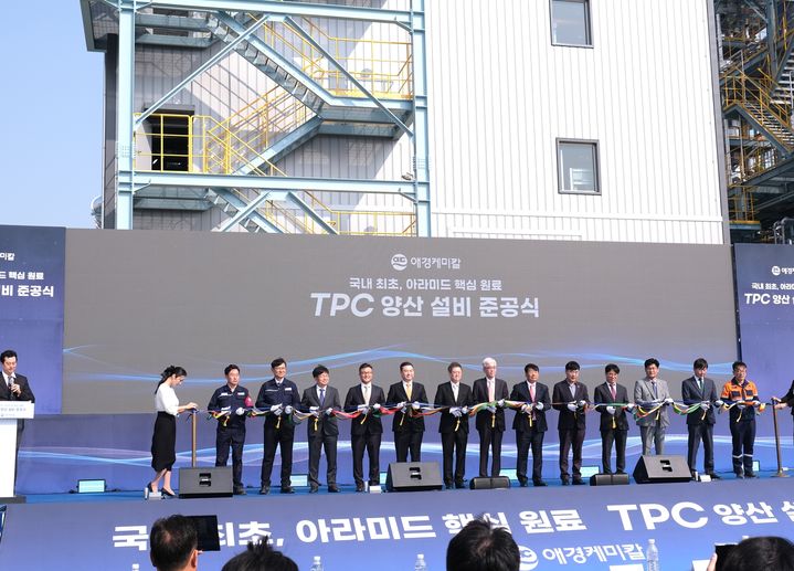 [서울=뉴시스] 송한규 에쓰씨엔지니어링 대표이사(오른쪽 네번째)가 26일 애경케미칼 울산공장에서 열린 아라미드 핵심 원료 TPC 양산 설비 준공식에서 테이프 커팅식에 참여하고 있다. (사진=에쓰씨엔지니어링) *재판매 및 DB 금지