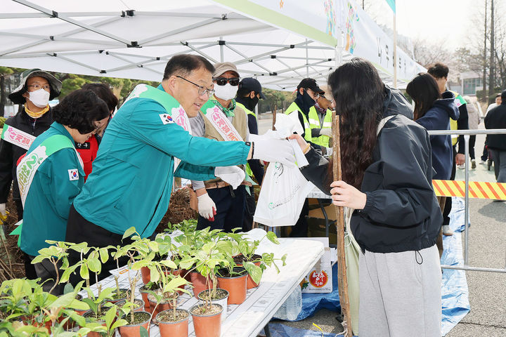 [창원=뉴시스] 강경국 기자 = 27일 오전 경남 창원스포츠파크 만남의 광장에서 열린 봄맞이 시민 나무 나누어 주기 행사에서 장금용 시장 권한대행이 시민들에게 나무를 나눠주고 있다. (사진=창원시청 제공). 2026.03.27. photo@newsis.com *재판매 및 DB 금지