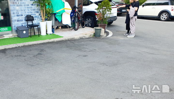 [창원=뉴시스] 강경국 기자 = 지난 27일 오전 경남 창원시의 한 아파트 상가 주차장에서 칼부림 사건이 발생한 가운데 28일 오후 행인들이 사고 현장을 가리키고 있다. 2026.03.28. kgkang@newsis.com
