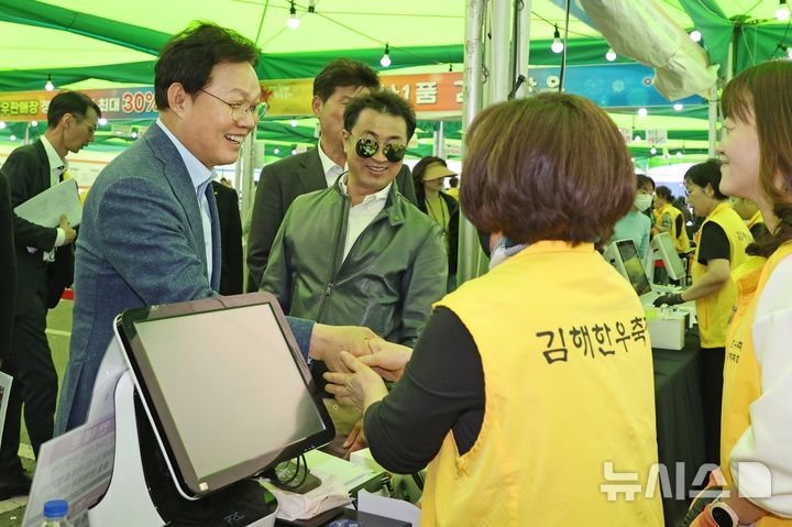 [김해=뉴시스]박완수 경남도지사가 28일 롯데프리미엄아울렛 김해점 일원에서 열리고 있는 김해축산업협동조합 주최·주관 '제2회 김해 한우축제' 현장을 찾아 관계자들과 악수하며 격려하고 있다.(사진=경남도 제공) 2026.03.28. photo@newsis.com