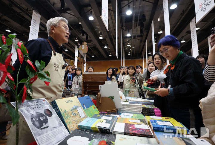 [파주=뉴시스] 이영환 기자 = 문재인 전 대통령이 28일 오후 경기 파주시 아시아출판정보문화센터 지혜의숲 다목적홀에서 열린 DMZ세계문학페스타 2026 북페어 '사이에서' 평산책방 부스에서 시민들에게 도서를 추천하고 있다. 2026.03.28. 20hwan@newsis.com