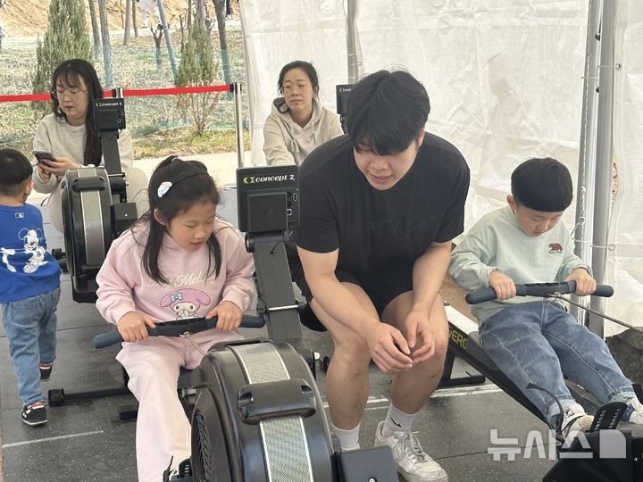 [논산=뉴시스] 김도현 기자 = 논산딸기축제에 방문한 시민들이 29일 오후 논산딸기축제 내에 설치된 '스트롱베리 미션 챌린지' 부스에서 미션3 로잉머신을 하고 있다. 2026.03.29. kdh1917@newsis.com