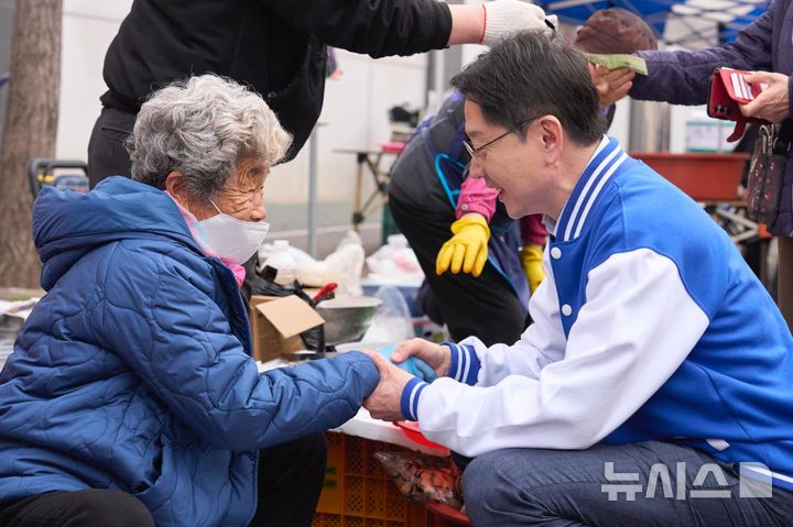 [창원=뉴시스]김경수 더불어민주당 경남도지사 후보가 일요일인 29일 이른 시간에 창원특례시 마산 번개시장을 찾아 노점상의 손을 잡고 인사하고 있다.(사진=김경수 후보 선거사무소 제공) 2026.03.29. photo@newsis.com