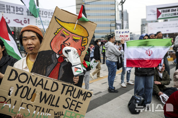 [서울=뉴시스] 정병혁 기자 = 29일 서울 종로구 열린송현광장에서 열린 '트럼프, 네타냐후의 전쟁에 반대한다' 땅의날 50주년 전국집중행동의날에서 참가자들이 피켓을 들고 있다. 2026.03.29. jhope@newsis.com