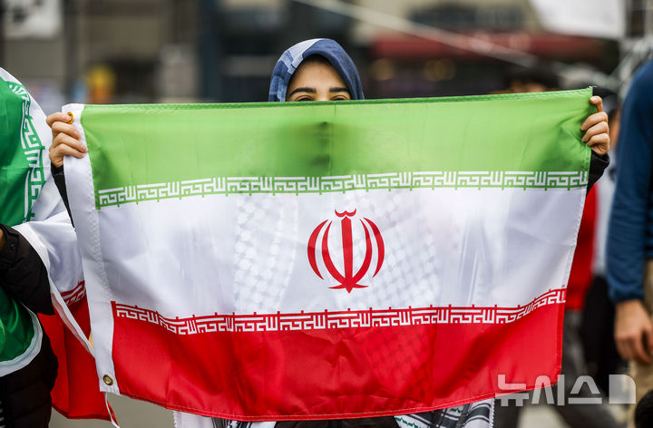 [서울=뉴시스] 정병혁 기자 = 29일 서울 종로구 열린송현광장에서 열린 '트럼프, 네타냐후의 전쟁에 반대한다' 땅의날 50주년 전국집중행동의날에서 한 참가자가 이란 국기를 들고 있다. 2026.03.29. jhope@newsis.com