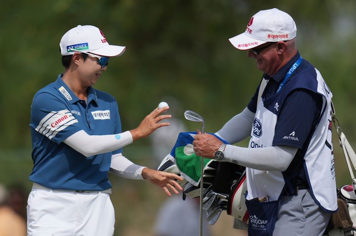 [챈들러=AP/뉴시스] 김효주(왼쪽)가 29일(현지 시간) 미 애리조나주 챈들러 윌윈드 골프클럽에서 열린 미국여자프로골프(LPGA) 투어 포드 챔피언십 최종 라운드 3번 홀에서 버디를 기록한 후 캐디 트래비스 윌슨에게 클럽을 전달하고 있다. 디펜딩 챔피언 김효주는 최종 합계 28언더파 260타로 우승하며 2연패를 달성했다. 2026.03.30.