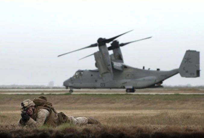 [서울=뉴시스]2015년 10월6일 스페인 세비야 인근 모론 공군기지에서 열린 미-스페인 합동훈련에서 미 해병대원 1명이 V-22 오스프레이기 옆에서 사격 자세를 취하고 있다. 스페인 정부는 영국과 프랑스 등 제3국에 배치된 미국 항공기를 포함해 미국과 이스라엘의 이란 군사 공격과 관련된 모든 항공편에 대해 스페인 영공을 폐쇄했다고 스페인 신문 엘 파이스가 30일 보도했다. <사진 출처 : 뉴스위크> 2026.03.30.