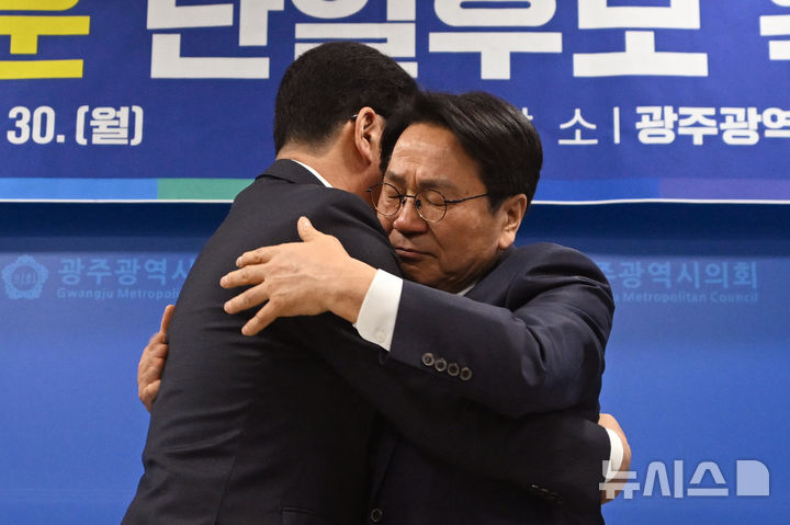 [광주=뉴시스] 이영주 기자 = 더불어민주당 전남광주통합특별시장 본경선 주자인 강기정(오른쪽) 예비후보가 30일 오전 광주 서구 광주시의회에서 열린 신정훈 예비후보와의 단일화 후보 확정 회견을 마치고 신 후보를 안고 있다. 2026.03.30. leeyj2578@newsis.com