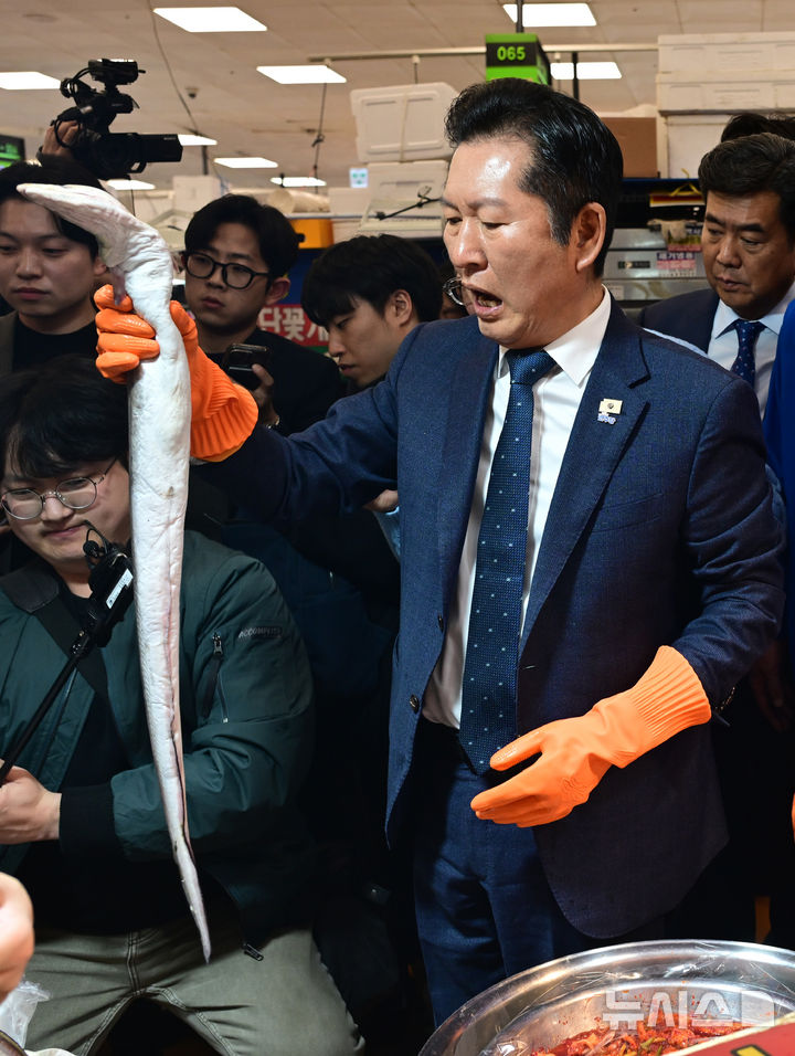 [서울=뉴시스] 정병혁 기자 = 정청래 더불어민주당 대표가 30일 서울 동작구 노량진수산시장을 찾아 갈치를 들고 있다. (공동취재) 2026.03.30. photo@newsis.com