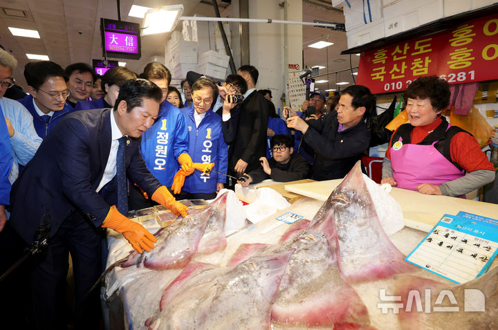 [서울=뉴시스] 정병혁 기자 = 정청래 더불어민주당 대표를 비롯한 서울시장 경선후보로 출마한 정원오, 박주민 전현희 후보가 30일 서울 동작구 노량진수산시장을 찾아 홍어를 살펴보고 있다. (공동취재) 2026.03.30. photo@newsis.com