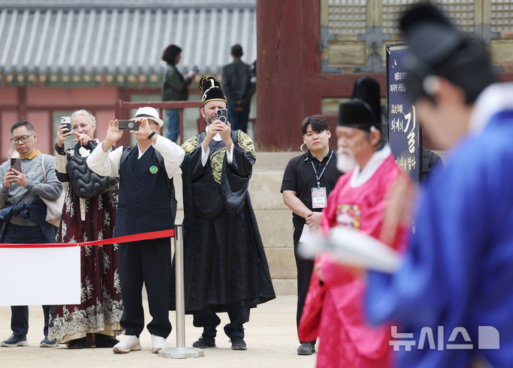 [서울=뉴시스] 김진아 기자 = 30일 서울 경복궁 사정전에서 열린 '제6회 퇴계 선생 마지막 귀향길 재현행사' 출정식에서 외국인 관광객들이 행사 모습을 촬영하고 있다. 2026.03.30. bluesoda@newsis.com
