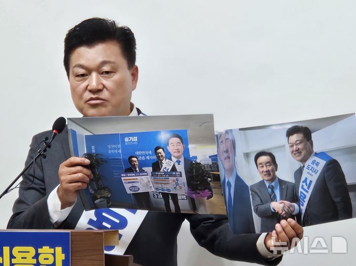 [청주=뉴시스] 이도근 기자= 신용한 더불어민주당 충북지사 예비후보가 31일 충북도청 브리핑룸에서 기자회견을 열어 송기섭 전 진천군수와 함께 찍은 사진을 들어보이고 있다. 2026.03.31. nulha@newsis.com