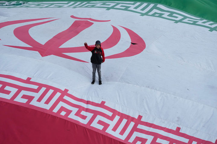 [테헤란=AP/뉴시스] 1일(현지 시간) 이란 테헤란에서 이스라엘의 공습으로 지난 3월 말 사망한 알리레자 탕시리 이란 혁명수비대(IRGC) 해군 사령관과 다른 희생자들의 장례 행렬이 진행되는 동안 한 소년이 대형 이란 국기 위에 올라가 구호를 외치고 있다. 2026.04.02.