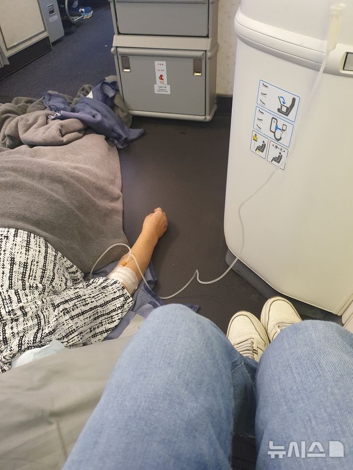 [서울=뉴시스] 필리핀 마닐라행 비행기에서 응급 처지 중인 대한가정의학회 의사들. (사진=김정환 강남을지대병원 교수 제공)