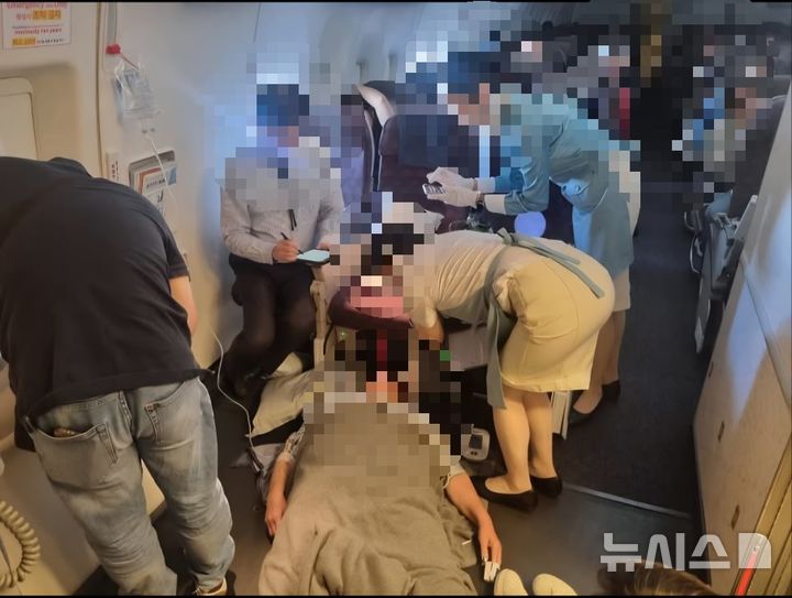 [서울=뉴시스] 필리핀 마닐라행 비행기에서 응급 처지 중인 대한가정의학회 의사들. (사진=김정환 강남을지대병원 교수 제공) 