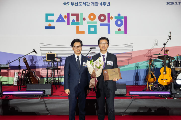 [부산=뉴시스] 지난 3월31일 국회부산도서관에서 열린 '개관 4주년 기념 도서관 음악회'에서 이근희 부산환경공단 이사장(오른쪽)이 국회의장 공로패를 수상, 황정근 국회도서관장과 함께 기념 사진을 찍고 있다. (사진=부산환경공단 제공) 2026.04.01. photo@newsis.com *재판매 및 DB 금지