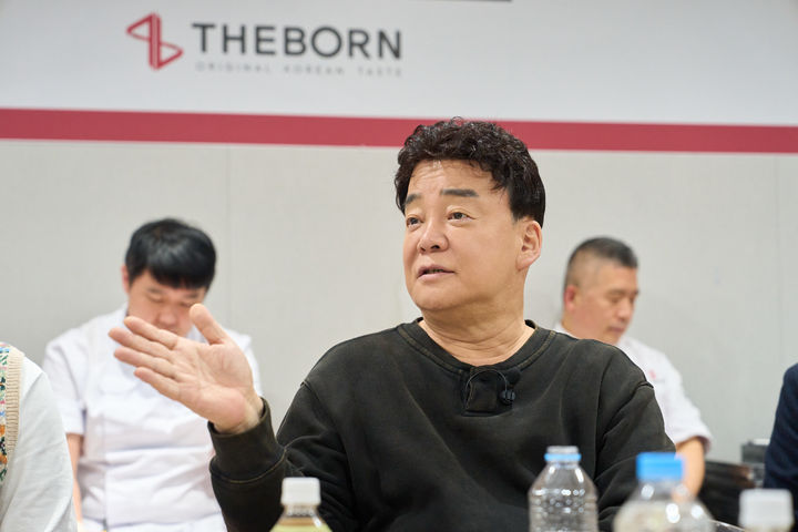 [서울=뉴시스] 백종원 더본코리아 대표이사가 해외 마스터 프랜차이즈 대표단·가맹점주와 얘기하고 있다.(사진=더본코리아) *재판매 및 DB 금지