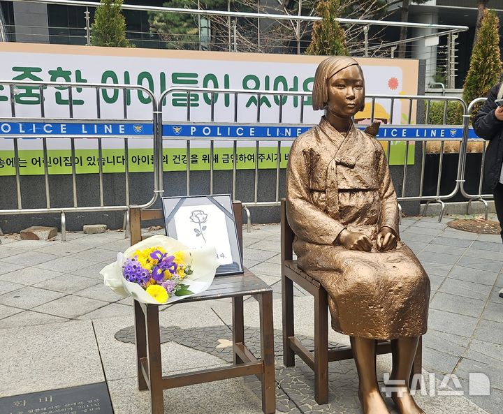 [서울=뉴시스] 조성하 기자 = ﻿서울 종로구 옛 주한 일본대사관 인근 평화의 소녀상이 1일 수요시위에서 약 6년 만에 경찰 바리케이드를 벗어나 시민들 앞에 모습을 드러냈다. 이날 시위에서는 최근 별세한 일본군 '위안부' 피해자를 기리는 추모도 함께 진행됐다. 사진은 이날 평화의 소녀상 앞에 추모 꽃과 영정이 놓여 있는 모습. 2026.04.01. create@newsis.com