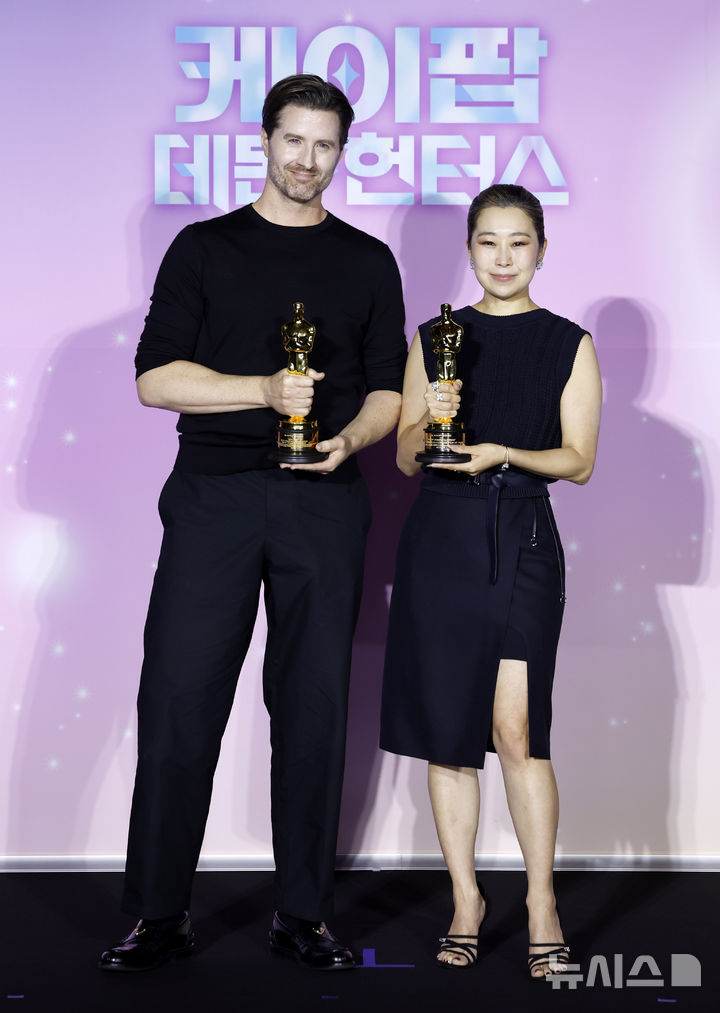 포즈 취하는 크리스 애플한스-매기 강 감독