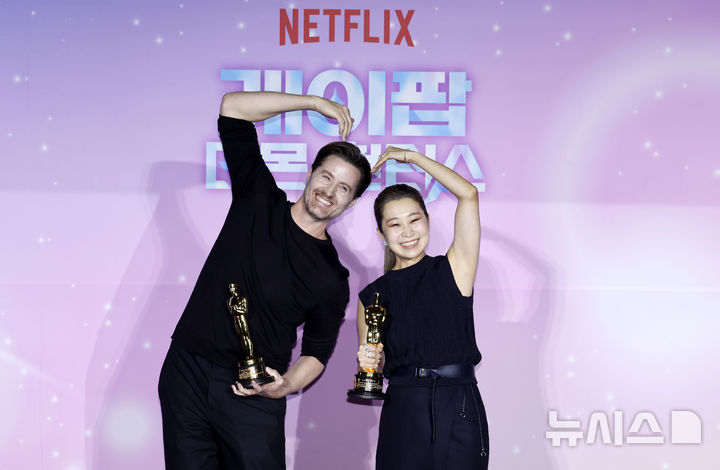 포즈 취하는 크리스 애플한스-매기 강 감독