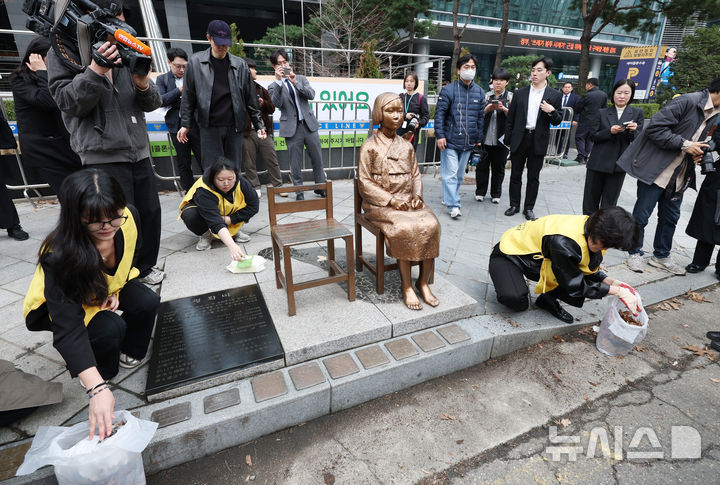 [서울=뉴시스] 김진아 기자 = 1일 서울 종로구 옛 주한 일본대사관 앞에서 열린 제1746차 일본군 성노예제 문제해결을 위한 정기 수요시위에서 앞서 참가자들이 바리케이드가 철거된 소녀상을 닦고 있다. 평화의 소녀상은 이날 수요시위에서 약 6년 만에 경찰 바리케이드를 벗어나 시민들 앞에 모습을 드러냈다. 안전 문제를 고려해 전면 철거 대신 한시 개방 방식을 택한 것으로 전해졌다. 경찰은 4월 말께 바리케이드 철거 여부를 다시 판단할 방침이다. 2026.04.01. bluesoda@newsis.com