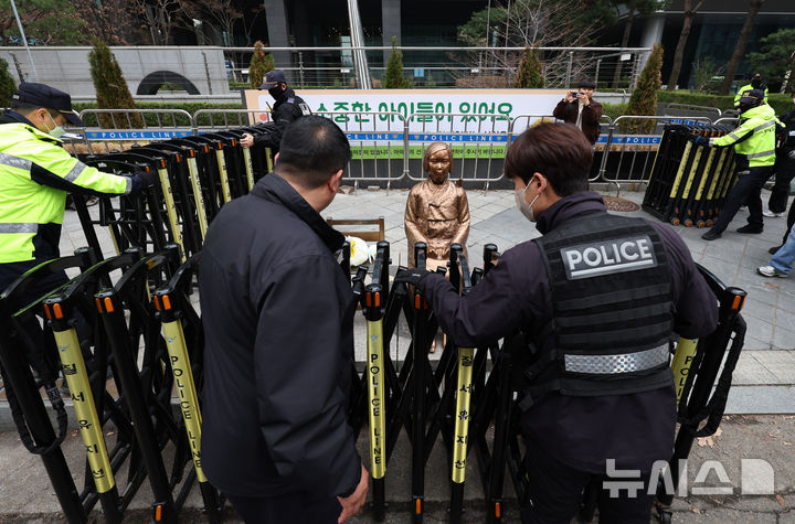 [서울=뉴시스] 김진아 기자 = 1일 서울 종로구 옛 주한 일본대사관 앞에서 열린 제1746차 일본군 성노예제 문제해결을 위한 정기 수요시위에서 경찰들이 집회 끝난 뒤 소녀상 주위에 바리케이드를 설치하고 있다. 평화의 소녀상은 이날 수요시위에서 약 6년 만에 경찰 바리케이드를 벗어나 시민들 앞에 모습을 드러냈다. 안전 문제를 고려해 전면 철거 대신 한시 개방 방식을 택한 것으로 전해졌다. 경찰은 4월 말께 바리케이드 철거 여부를 다시 판단할 방침이다. 2026.04.01. bluesoda@newsis.com