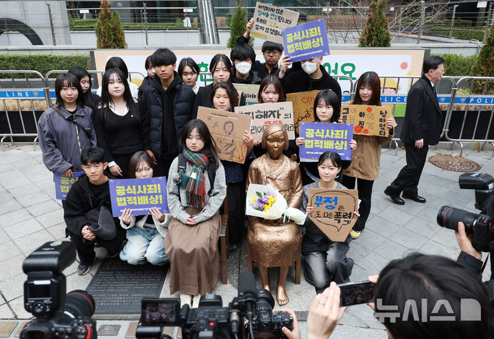 [서울=뉴시스] 김진아 기자 = 1일 서울 종로구 옛 주한 일본대사관 앞에서 열린 제1746차 일본군 성노예제 문제해결을 위한 정기 수요시위에서 참가자들이 소녀상과 사진을 찍고 있다. 평화의 소녀상은 이날 수요시위에서 약 6년 만에 경찰 바리케이드를 벗어나 시민들 앞에 모습을 드러냈다. 안전 문제를 고려해 전면 철거 대신 한시 개방 방식을 택한 것으로 전해졌다. 경찰은 4월 말께 바리케이드 철거 여부를 다시 판단할 방침이다. 2026.04.01. bluesoda@newsis.com
