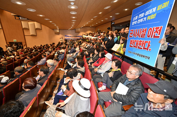 [무안=뉴시스] 박기웅 기자 = 1일 오후 전남 무안군 무안읍 승달문화예술회관 대강당에서 국방부 주관으로 '광주 군공항 이전 주민설명회'가 열린 가운데 한 주민이 군공항 이전 반대 피켓을 들고 있다. 2026.04.01. pboxer@newsis.com