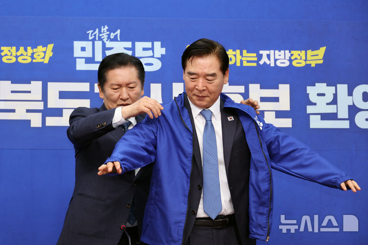 [서울=뉴시스] 김금보 기자 = 지방선거 더불어민주당 경북도지사 후보에 단수공천된 오중기 예비후보가 1일 오후 서울 여의도 국회에서 열린 환영식에서 정청래 대표로 부터 당 점퍼를 받아 입고 있다. 2026.04.01.kgb@newsis.com